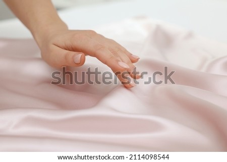Woman touching smooth silky fabric, closeup view Royalty-Free Stock Photo #2114098544