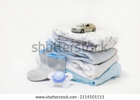 Baby clothes with booties and toy on table in room