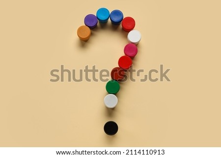 Question mark made of gouache paints on beige background