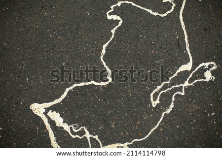 Paint on asphalt. Splashes of white paint on road. Soiled surface. Texture jet paint.