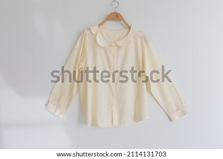 Minimal style.Yellow woman clothes is clothes hanger on white background.close up