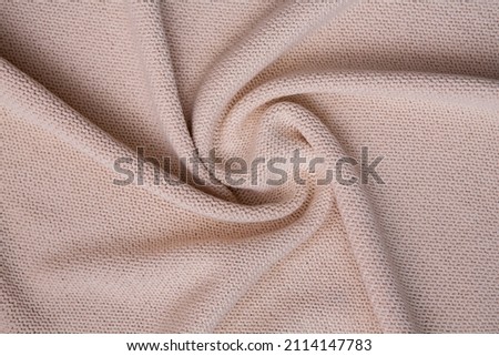 Knitted sweater texture closeup. Beige soft abstract background, copy space.