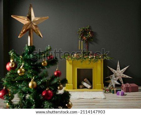 Close up Christmas tree with ornaments and star object, fireplace background with wood and Noel accessory happy new year decoration.