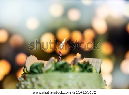 Happy birthday cake with candles on the background of bright lights bokeh.