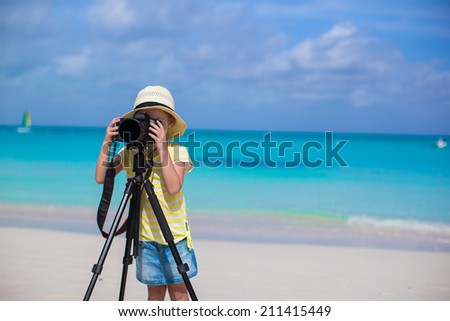 Little girl shooting with camera on tripod during her summer vacation