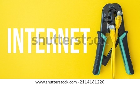 Crimper for RJ-45 and RJ-11 isolated on yellow background with word INTERNET. Internet concept illustration. Technical support. Internet of things concept. Close-up. Copy space. Royalty-Free Stock Photo #2114161220