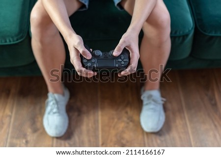 Teenager boy is playing on the console, video games, child with video game joystick. Gamepad playing video , enjoying weekend at home, kids entertaining concept, spending time in living room at home Royalty-Free Stock Photo #2114166167