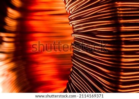 Copper wire coil. Toroidal transformer close-up. Bright image of copper. A selective focus. Royalty-Free Stock Photo #2114169371