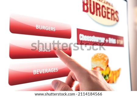 Self service and order kiosk in restaurant. Fast food touch screen, digital vending machine. Man using electronic menu and buying burger meal and paying with selfservice technology.