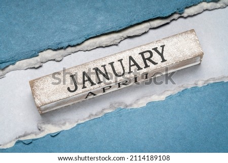 January text on grunge wooden block against handmade rag paper in blue tones, calendar concept