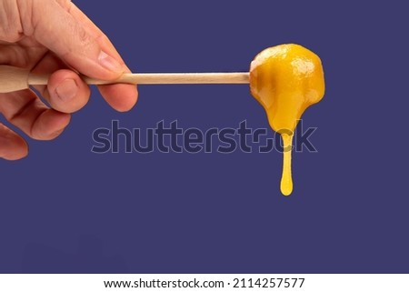 Fresh viscous flower honey falls down from a wooden spoon. vitamin organic food Royalty-Free Stock Photo #2114257577