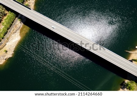 Bridge across reservoir, aerial shot, sunny day green water dam of Avila. Spain