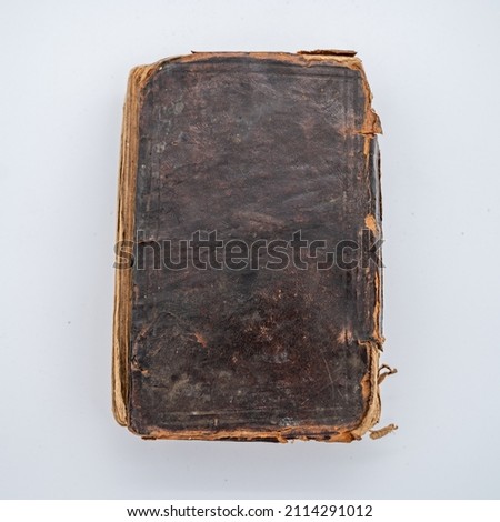 An Old Leather Covered Book Sits Flat. Worn edges lighten the color of the leather.  Royalty-Free Stock Photo #2114291012