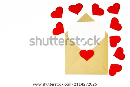 A kraft envelope with red hearts on a white background. A white sheet for a note in an envelope. The concept of Valentine's day, love, anniversary. copy space. flatlay