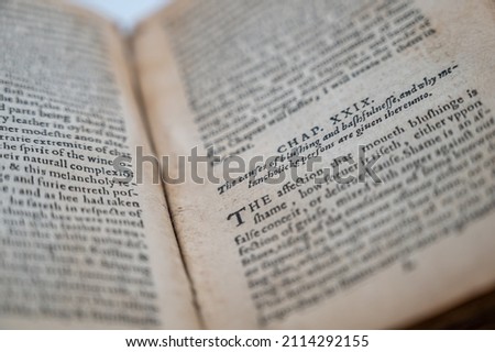 An Old English Book Is Opened To A Section Of The Novel Revealing Slightly Discolored Pages And Ancient English Writing. Royalty-Free Stock Photo #2114292155