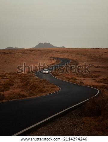 Car driving through road in the desert