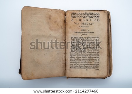 An Old English Book Sits Open To The Beginning Page Of The Book. A Treatise On Melancholie. The pages are aged, having a brown color.  Royalty-Free Stock Photo #2114297468