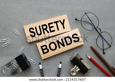 Surety bonds two wooden blocks on gray background business concept