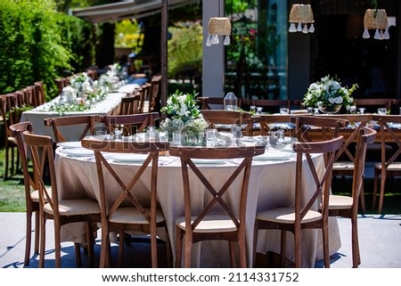 Wedding preparation restaurant and wedding planners.Chairs and honeymooners table decorated with candles, served with cutlery and crockery and covered with a table cloth. wedding area, party area, din