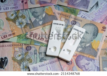 Romanian LEU banknotes and SARS CoV-2 rapid antigen test. Rapid test device for COVID-19 virus with a positive result. The lei is the national currency of Romania. RON, lei money, European currency.