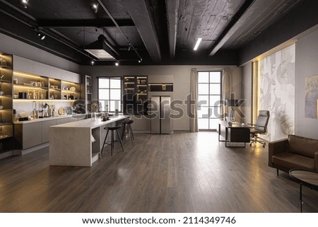 brutal interior of an ultra-modern spacious one-room apartment in dark colors super cool led lighting with kitchen, dining table and home office area Royalty-Free Stock Photo #2114349746