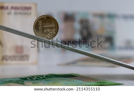 One ruble coin on inclined flat on blurred background of Russian rubles banknotes Royalty-Free Stock Photo #2114355110