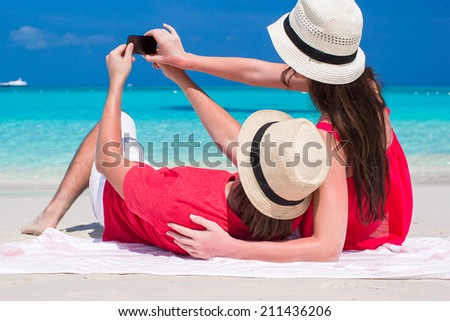 Happy couple taking a photo themselves on tropical beach