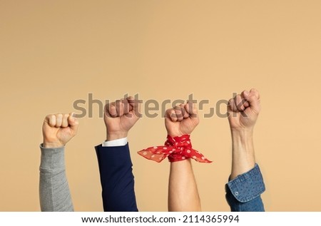 Four male hands on a beige background showing a fist, symbol of the feminist movement. Royalty-Free Stock Photo #2114365994