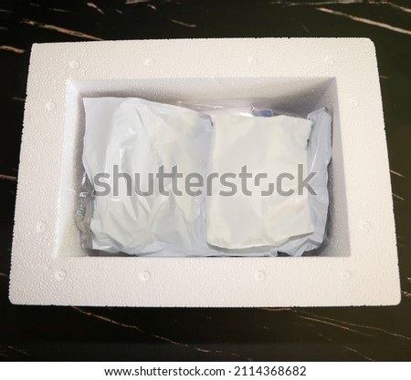 View of the inside of package received by mail with medication that needs refrigeration packed with gel refrigerant in a Styrofoam cooler.