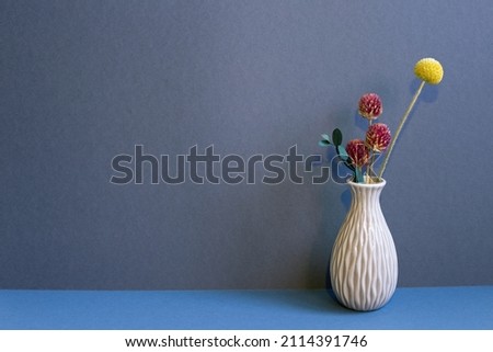 Vase of dry flowers on table. navy blue wall background. home interior decor
