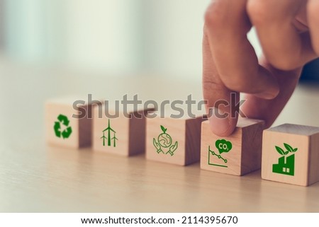Low carbon,carbon neutral concept. Net zero greenhouse gas emissions target. Climate neutral long term strategy. Hand put wooden cubes with decrease carbon emission icon and green icon. Green banner. Royalty-Free Stock Photo #2114395670