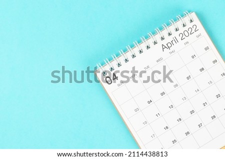 The April 2022 desk calendar on blue background with empty space. Royalty-Free Stock Photo #2114438813