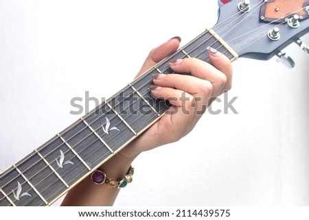 Closeup woman's finger playing acoustic guitar