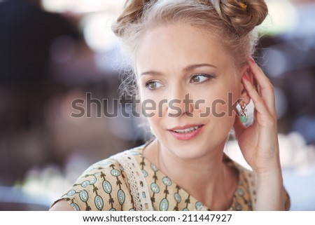 Portrait of a beautiful blonde girl in romantic retro dress on the street