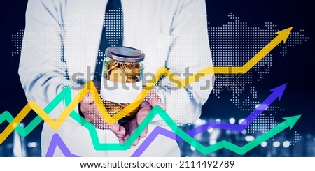 Businessman hands holding a glass jar full of money while standing with upward arrow and world map background