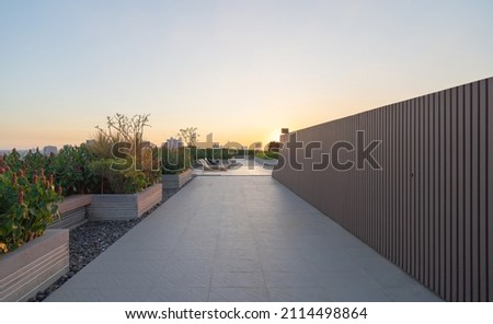 Sky garden on private rooftop of condominium or hotel, high rise architecture building with tree, grass field, and blue sky. Royalty-Free Stock Photo #2114498864