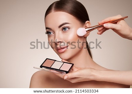 Makeup Artist applies Eye Shadow. Beautiful Woman Face. Perfect Makeup. Make-up detail. Beauty Girl with Perfect Skin. Nails and Manicure. Eye Shadow Palette Royalty-Free Stock Photo #2114503334