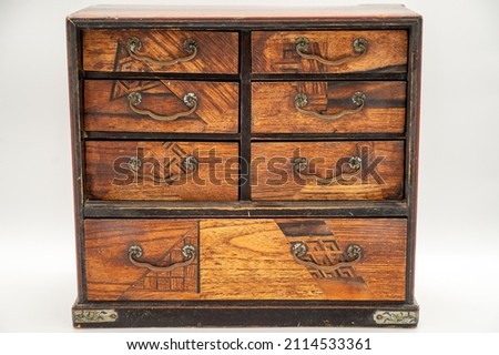 An Antique Jewelry Box Sits Facing Us Directly In Frame With Little Ornate Drawers Closed Holding Treasures Inside. Royalty-Free Stock Photo #2114533361