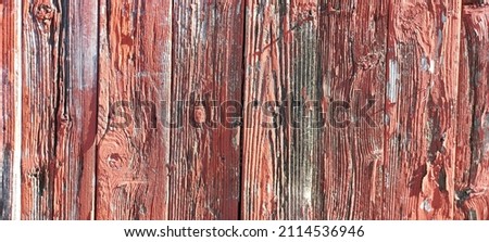 Backgrounds and textures: old red paint on the surface of a wooden fence. Place for text.