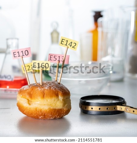 In the lab, a donut adorned with supplement name plates E. Food Laboratory. Healthy food concept.