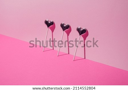 Valentines Day. Lollipop candy hearts on pink background. Minimal concept.