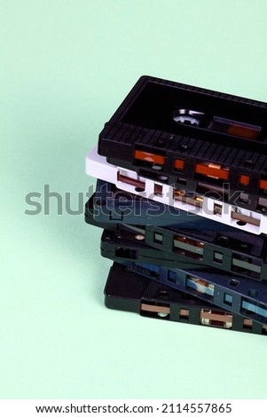 Stack of old vintage retro audio cassette tapes isolated on a green background