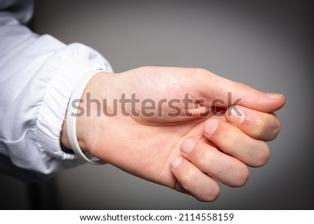 Closeup of a hand and wrist of a caucasian man isolated on gray background. Concept of carpal tunnel and joint pain due to inflammation of the tendons