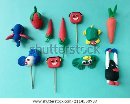 Various colorful models of animals and fruits made by kids using soft clay dough. Cute and colorful clay figures made by children.