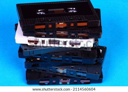 Stack of old vintage retro audio cassette tapes isolated on a blue background