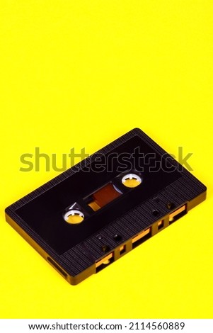 Vintage retro audio cassette tape isolated on a yellow background with copy space