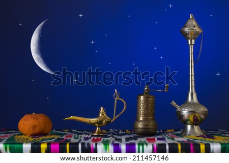 Muslim still life. Lamp, a mill, a hookah and dry tangerine.