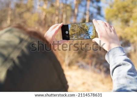 Taking nature photo with phone - Hand holding a smartphone taking pictures of mountain trees. Cellphone photography, capturing nature beauty and hobby photographer tourist concept.