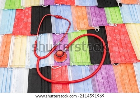 Red stethoscope on Color Surgical Mask background
