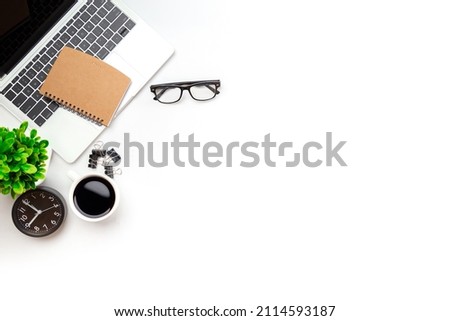White office desk table with blank notebook, computer keyboard and other office supplies. Top view with copy space, flat lay.